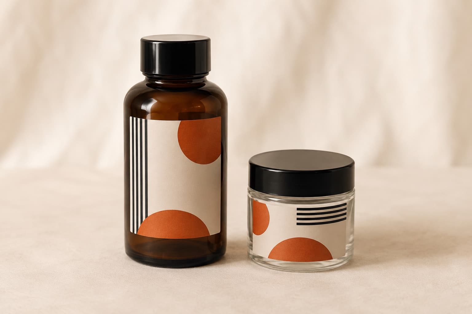 Amber glass bottle and clear glass jar, each with a cream vinyl label showing an orange half-circle